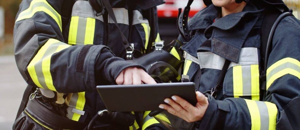 Firefighters reviewing digital fire protection plans related to fire and smoke curtain deployment