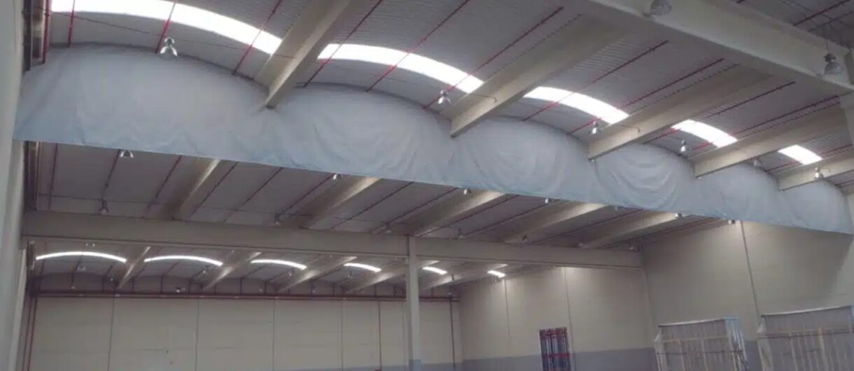 Smoke curtain system installed in an industrial ceiling to enhance SCTEH active fire protection performance