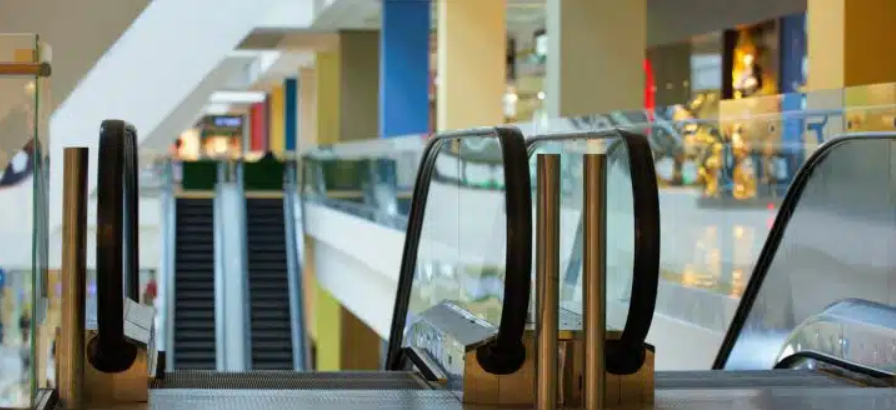 Escalators inside a shopping mall, highlighting the need for fire compartmentation and smoke control systems